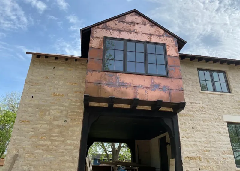 Copper metal panel facade on a stone building for Roof Repair in Lyndhurst